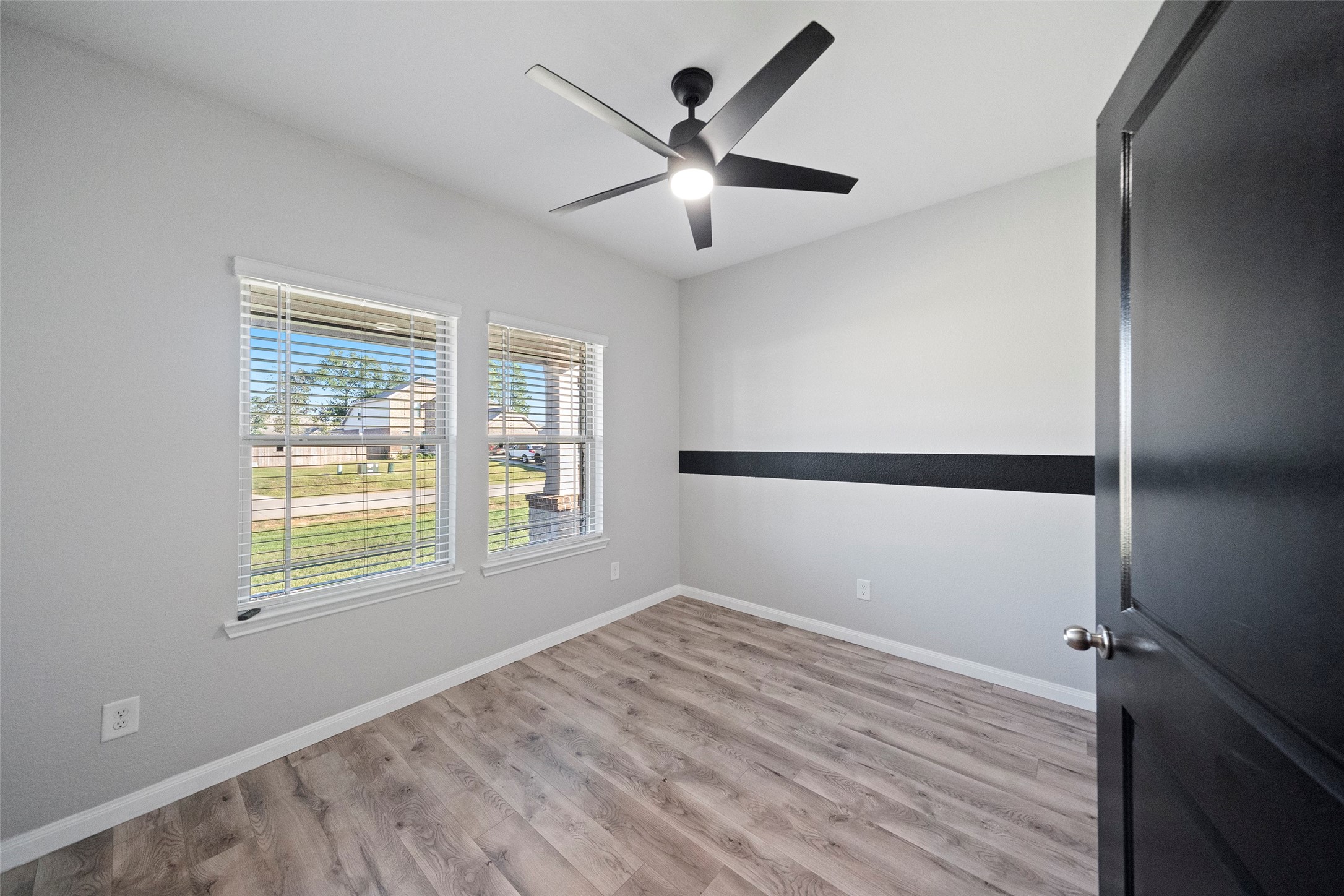 6161 White Oak Leaf Loop Conroe, TX 77303 - Photo 2 of 25 a view of an empty room with wooden floor and a window