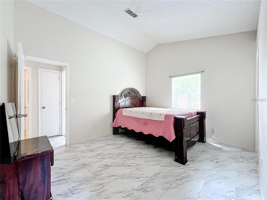 5633 Piney Ridge Drive Orlando, FL 32808 - Photo 11 of 18 a bedroom with a bed and a flat screen tv