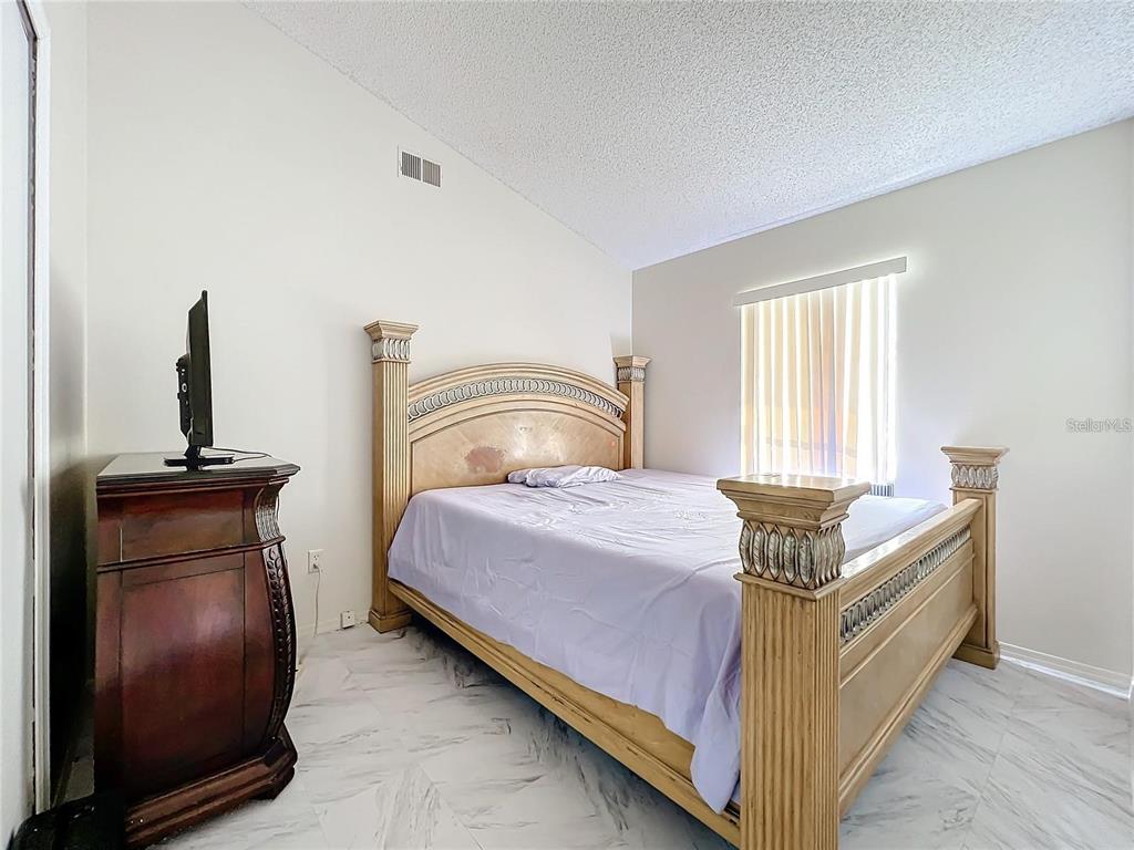 5633 Piney Ridge Drive Orlando, FL 32808 - Photo 13 of 18 a bedroom with a bed and a window
