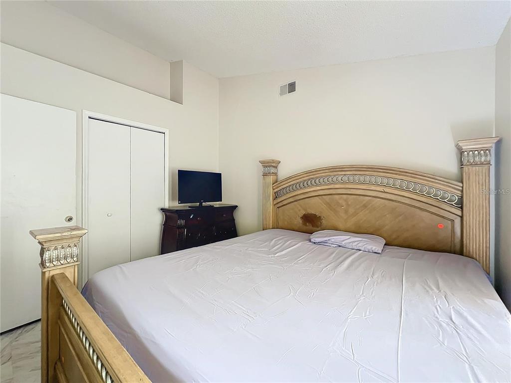 5633 Piney Ridge Drive Orlando, FL 32808 - Photo 14 of 18 a bedroom with a bed and a television