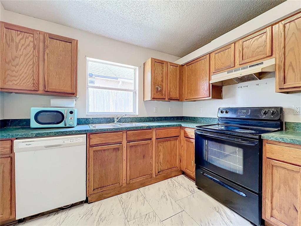 5633 Piney Ridge Drive Orlando, FL 32808 - Photo 6 of 18 a kitchen with granite countertop cabinets stainless steel appliances and a sink