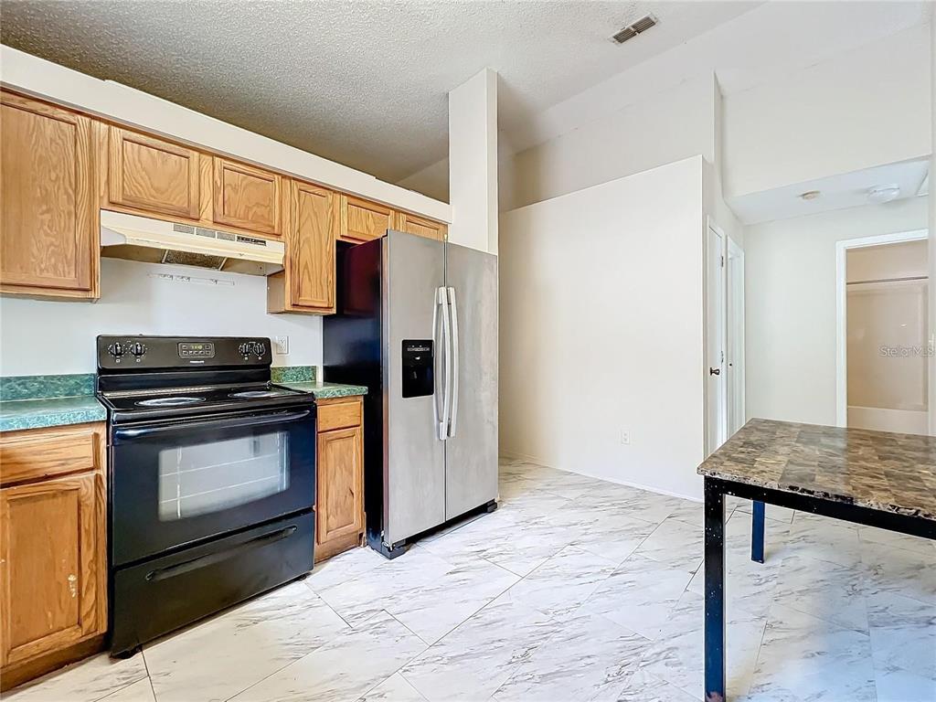 5633 Piney Ridge Drive Orlando, FL 32808 - Photo 7 of 18 a kitchen with a stove and a refrigerator