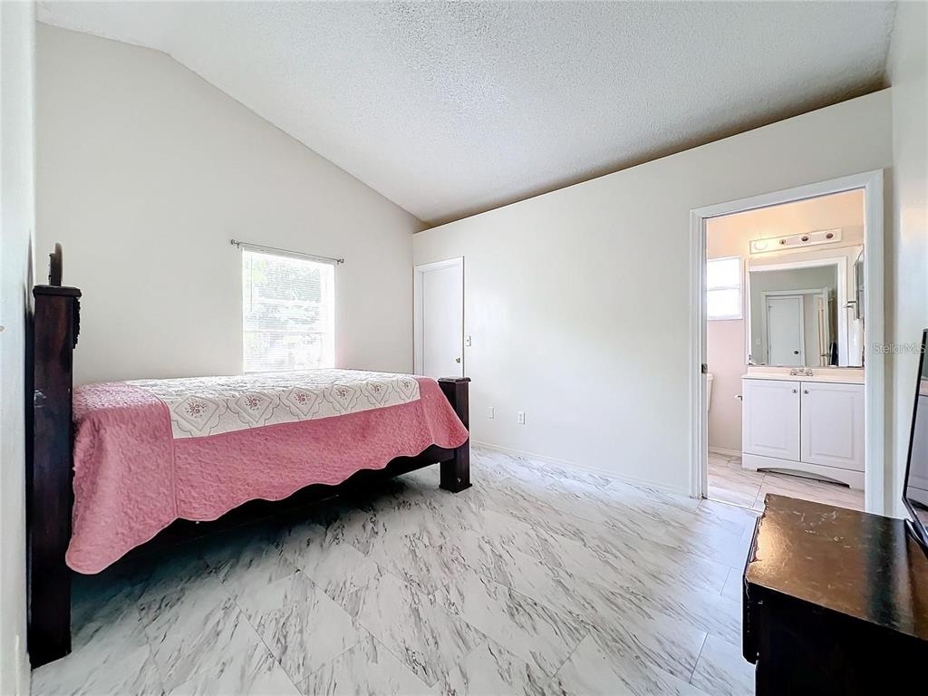 5633 Piney Ridge Drive Orlando, FL 32808 - Photo 9 of 18 a bedroom with a bed and wooden floor