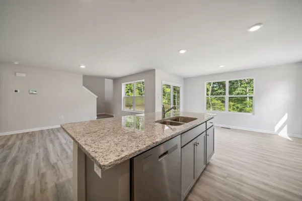 a kitchen with granite countertop sink stove and cabinets