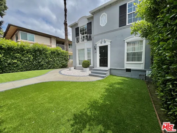 a front view of a house with a garden