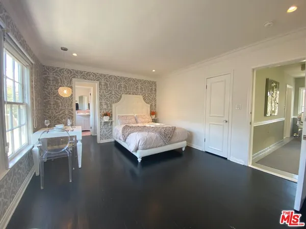a bedroom with a bed and large windows