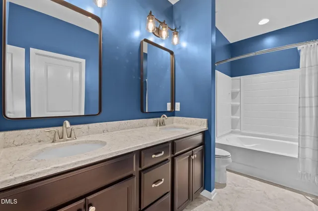 a bathroom with a granite countertop sink double vanity and a mirror