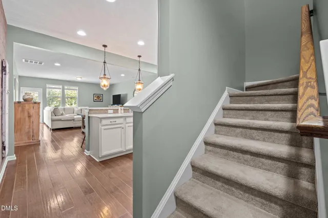a open kitchen with white cabinets and wooden floor