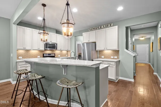 a kitchen with kitchen island a counter space a sink appliances and cabinets