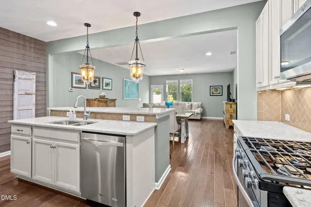 a kitchen with a sink stove and wooden floor