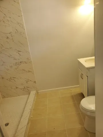 a bathroom with a toilet and a shower