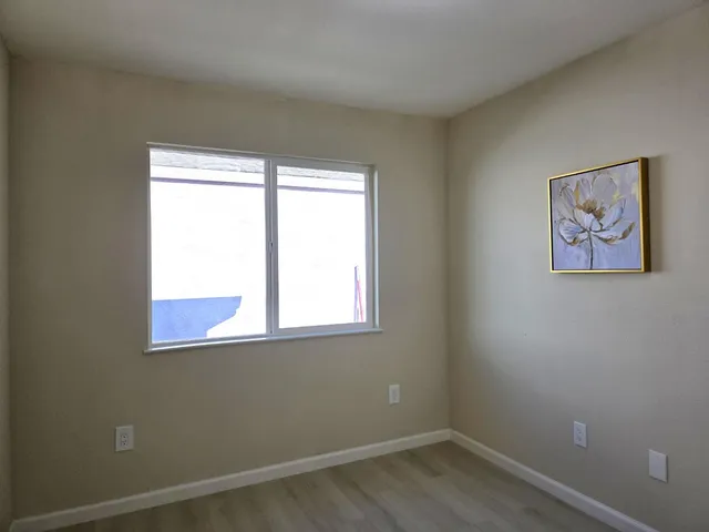 an empty room with a painting on the wall