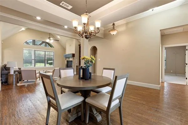 a view of a dining room with furniture a chandelier and wooden floor