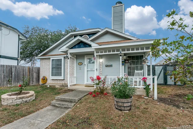 a front view of a house with a yard and potted plants