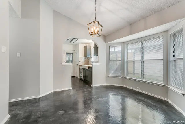 a view of a big room with windows and chandelier