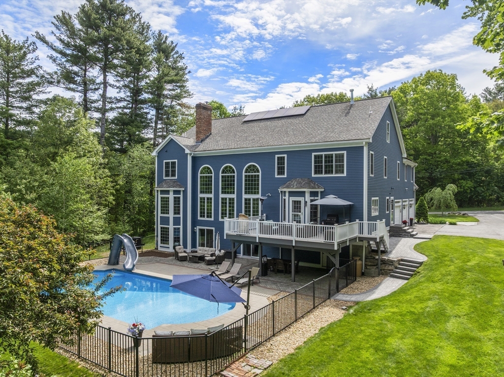 220 Newtown Road Acton, MA 01720 - Photo 34 of 39 a view of a house with backyard sitting area and garden