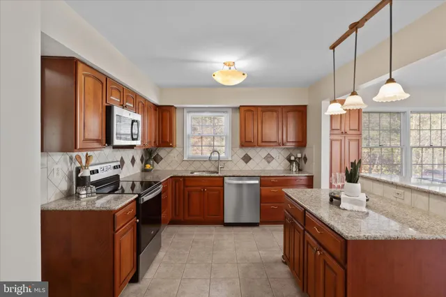 a kitchen with stainless steel appliances granite countertop a sink stove and cabinets