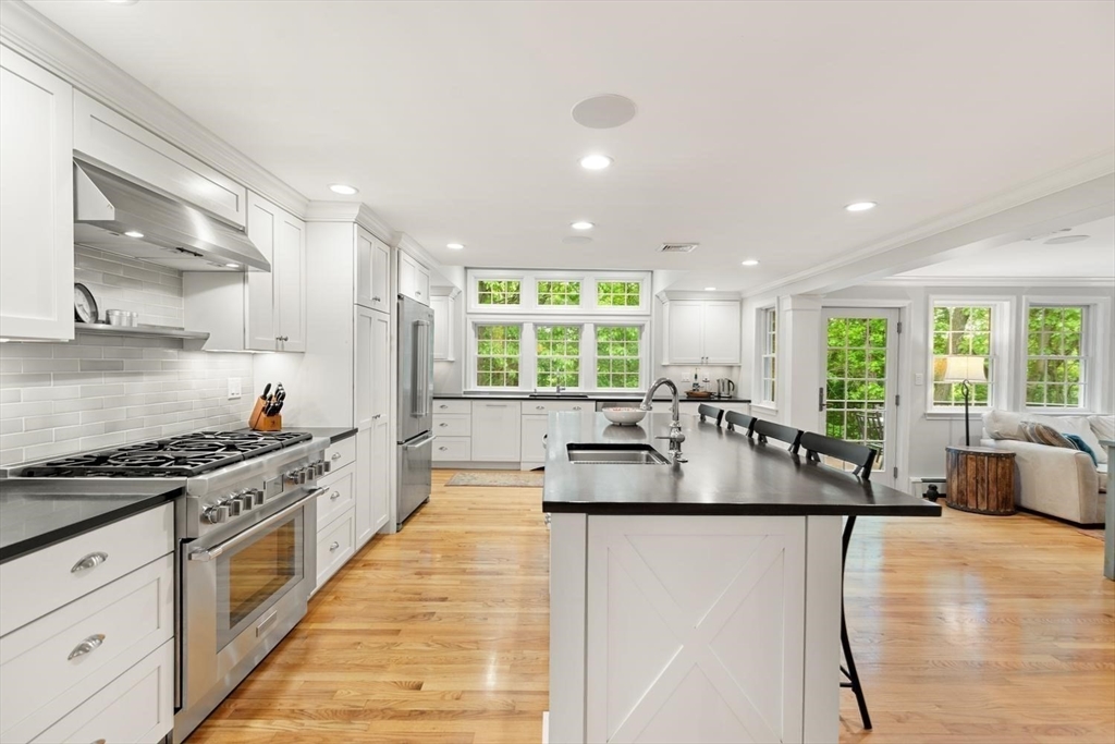 105 Thornberry Road Winchester, MA 01890 - Photo 4 of 35 a large kitchen with stainless steel appliances a large counter top a stove a chimney a sink and a large window