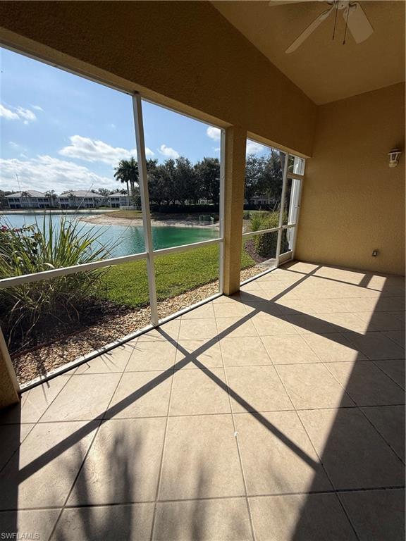 Unfurnished sunroom featuring a patio area, a water view, and ceiling fan