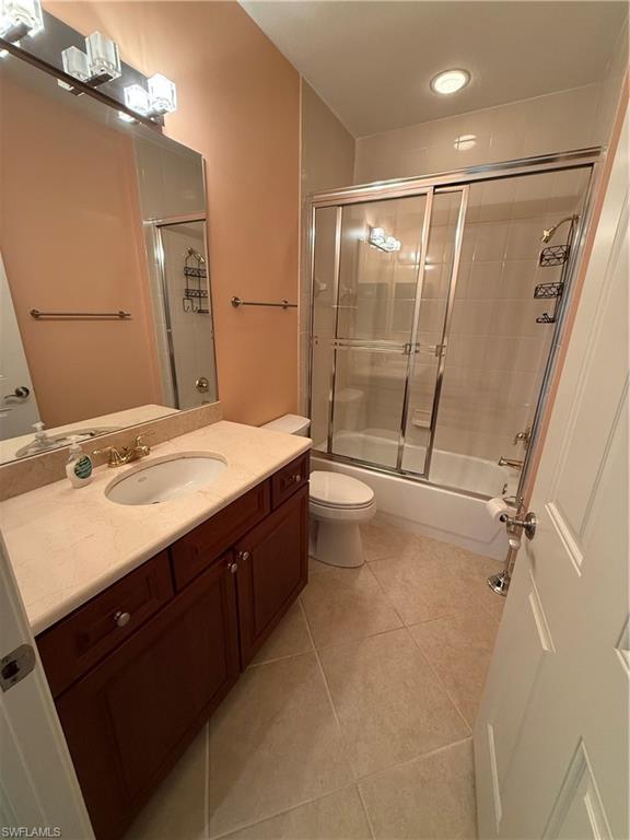 7168 Lemuria Circle, Unit 1701 Naples, FL 34109 - Photo 14 of 30 Bathroom featuring vanity, light tile patterned flooring, and combined bath / shower with glass door