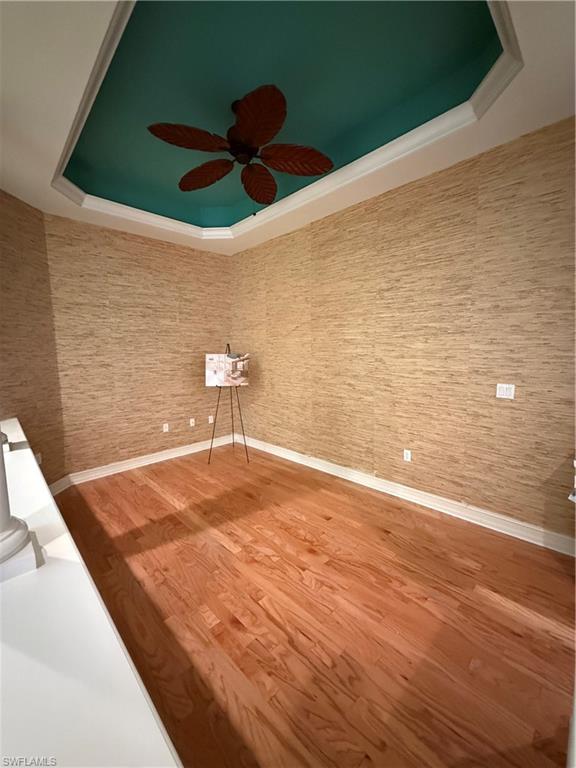 7168 Lemuria Circle, Unit 1701 Naples, FL 34109 - Photo 17 of 30 Unfurnished room with a raised ceiling, wood finished floors, and a ceiling fan