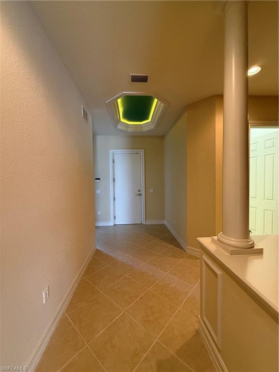 7168 Lemuria Circle, Unit 1701 Naples, FL 34109 - Photo 23 of 30 Hall featuring light tile patterned flooring and a textured wall