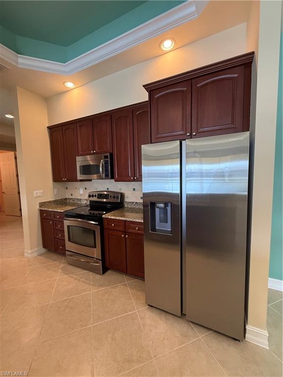 7168 Lemuria Circle, Unit 1701 Naples, FL 34109 - Photo 4 of 30 Kitchen with stainless steel appliances, light stone counters, recessed lighting, tasteful backsplash, and light tile patterned floors