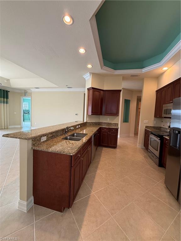 7168 Lemuria Circle, Unit 1701 Naples, FL 34109 - Photo 5 of 30 Kitchen with a raised ceiling, a peninsula, dark stone counters, refrigerator, and light tile patterned floors