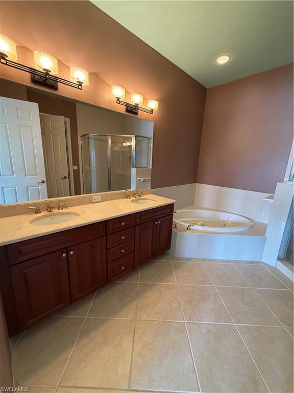 7168 Lemuria Circle, Unit 1701 Naples, FL 34109 - Photo 8 of 30 Full bath featuring double vanity, a shower stall, light tile patterned floors, and a bath