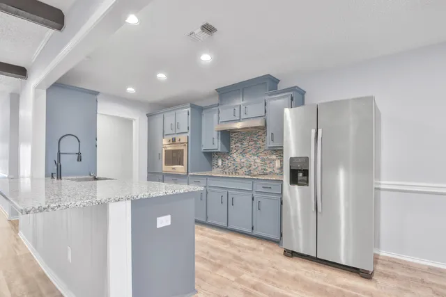 a kitchen with stainless steel appliances granite countertop a refrigerator and a sink