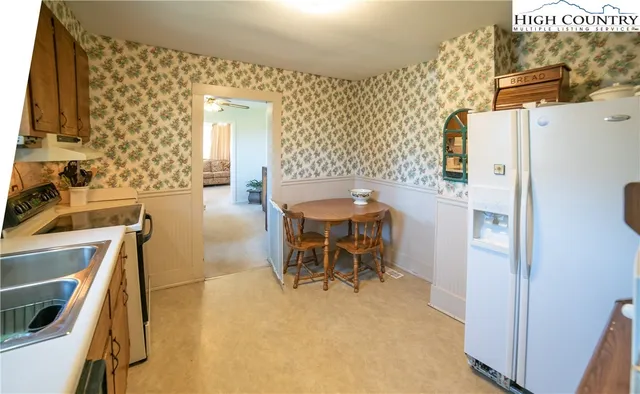 a dining room with furniture and a refrigerator
