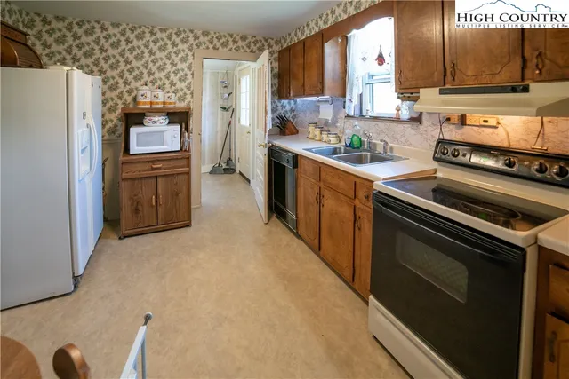 a kitchen with stainless steel appliances a stove a sink and a refrigerator