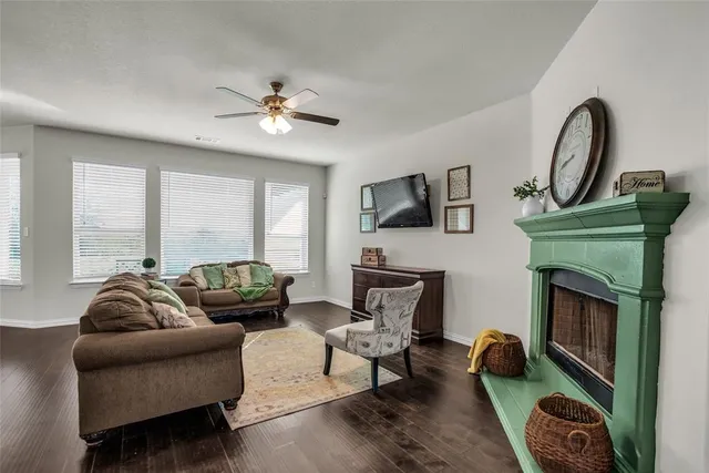 a living room with furniture a fireplace and a floor to ceiling window