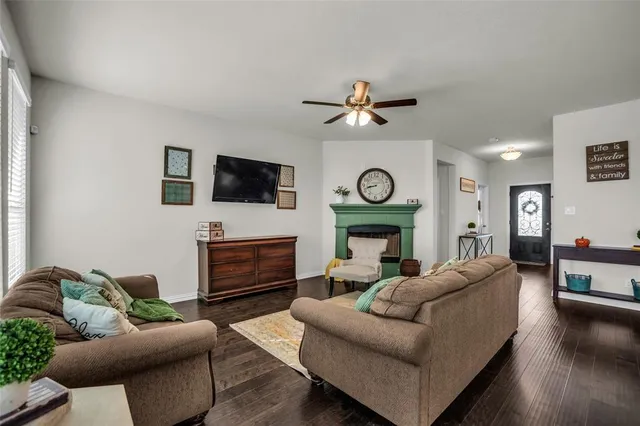 a living room with furniture a clock and a flat screen tv