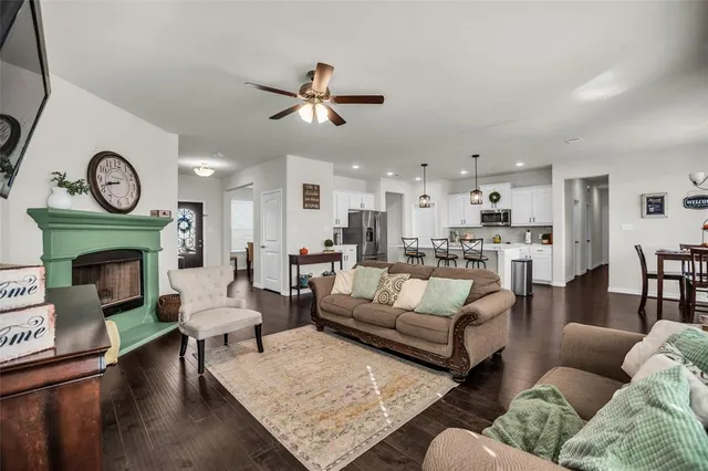 a living room with furniture a clock on wall and a fireplace