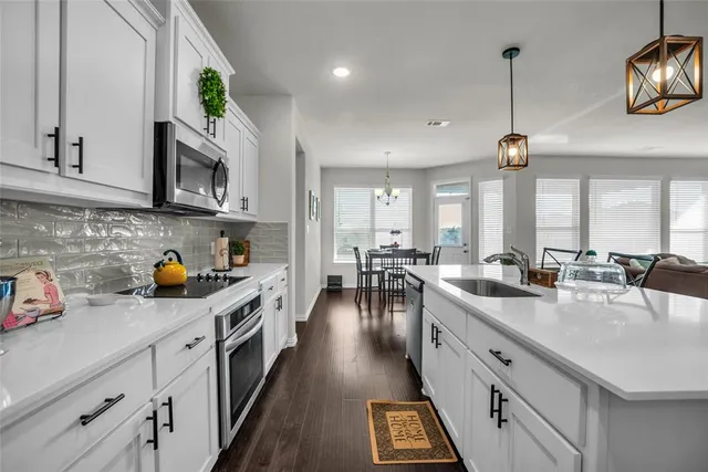 a kitchen with lots of counter space appliances and cabinets