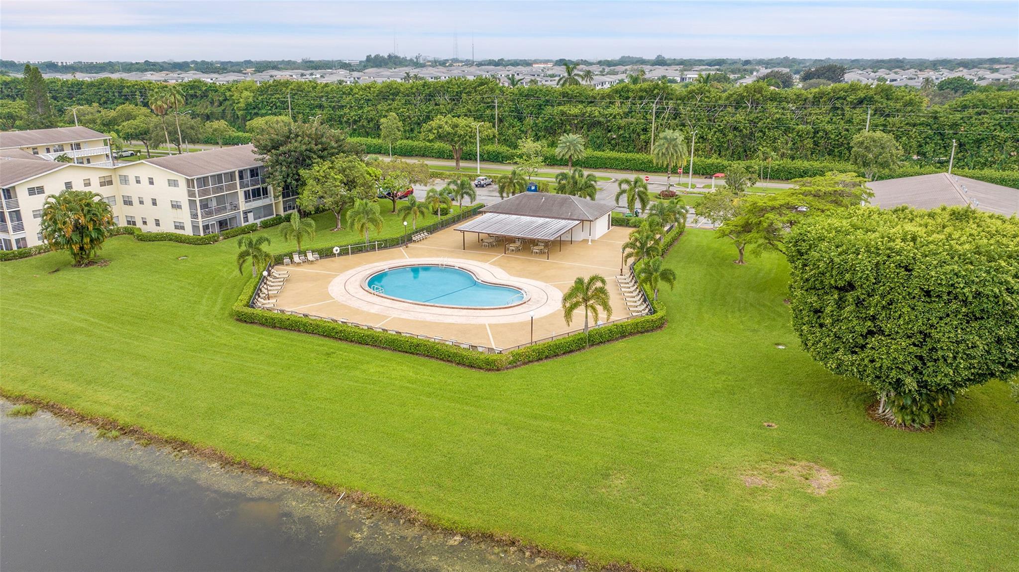 336 Dorset H Boca Raton, FL 33434 - Photo 7 of 12 a view of a swimming pool with a yard and lake view