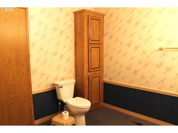 a bathroom with a granite countertop toilet and a sink