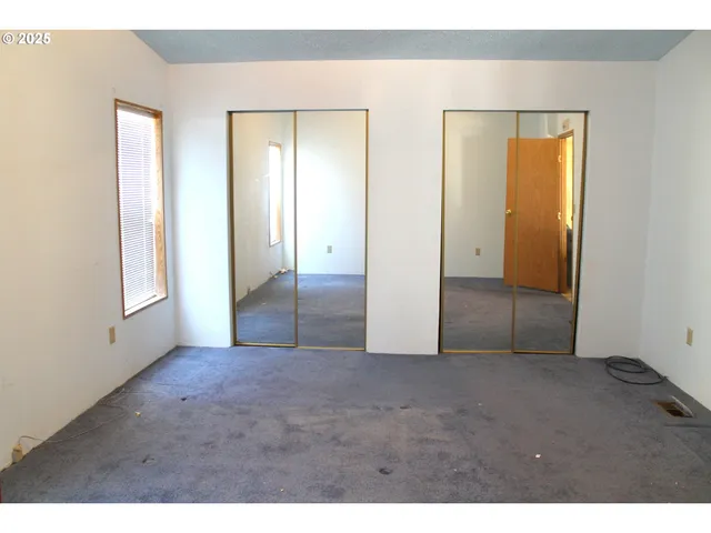 an empty room with windows and closet