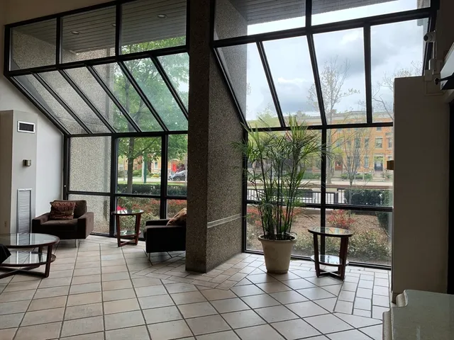 a living room with glass windows and furniture