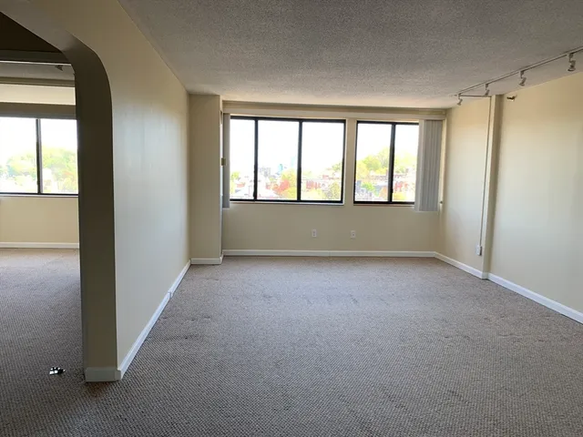 an empty room with windows and closet
