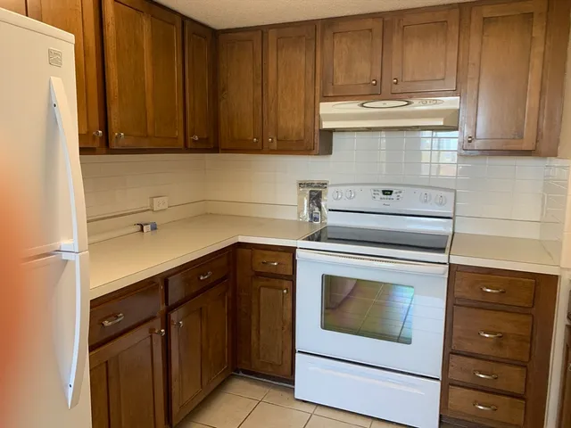 a kitchen with appliances cabinets and a counter top space