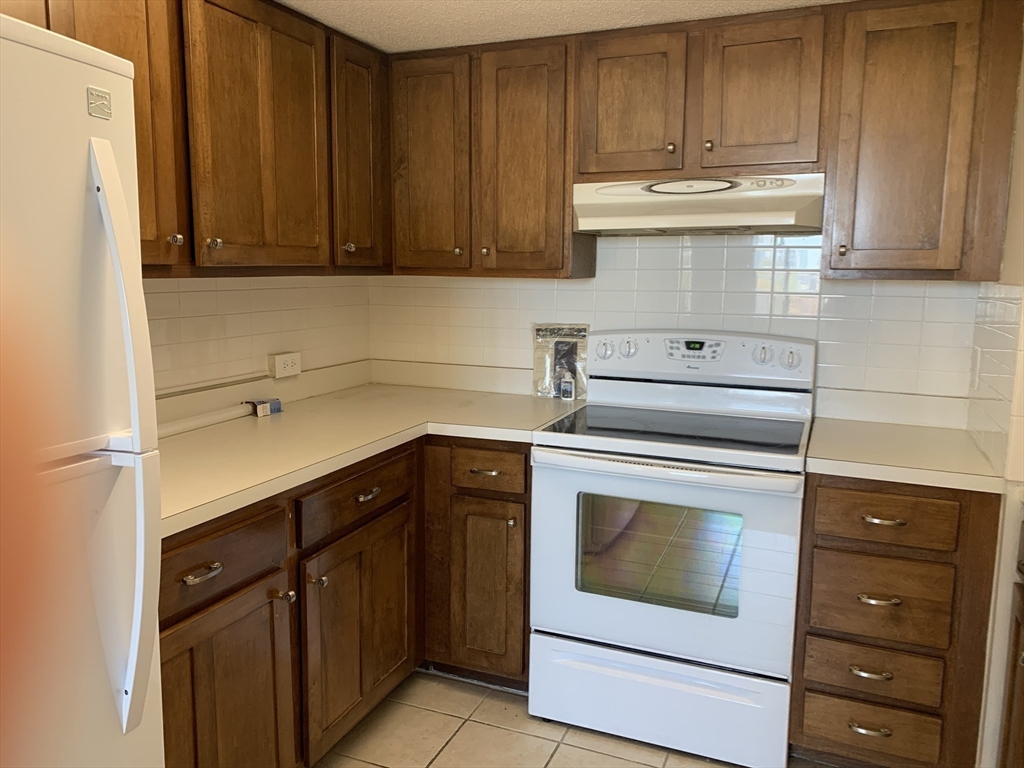 1731 Beacon Street, Unit 1213 Brookline, MA 02445 - Photo 26 of 29 a kitchen with appliances cabinets and a counter top space