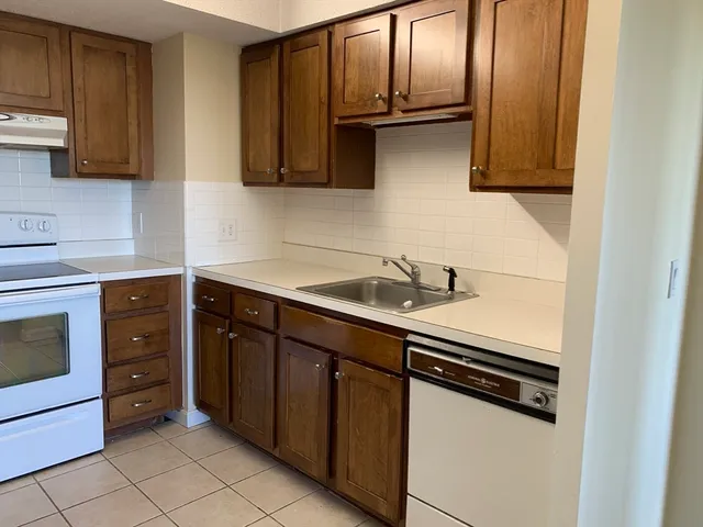 a kitchen with stainless steel appliances granite countertop a sink and a stove