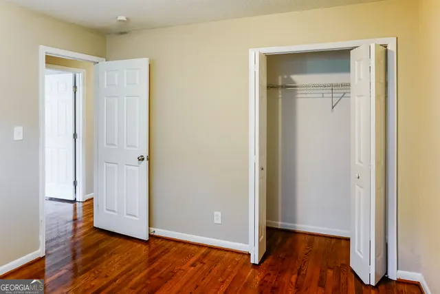 an empty room with wooden floor and closet
