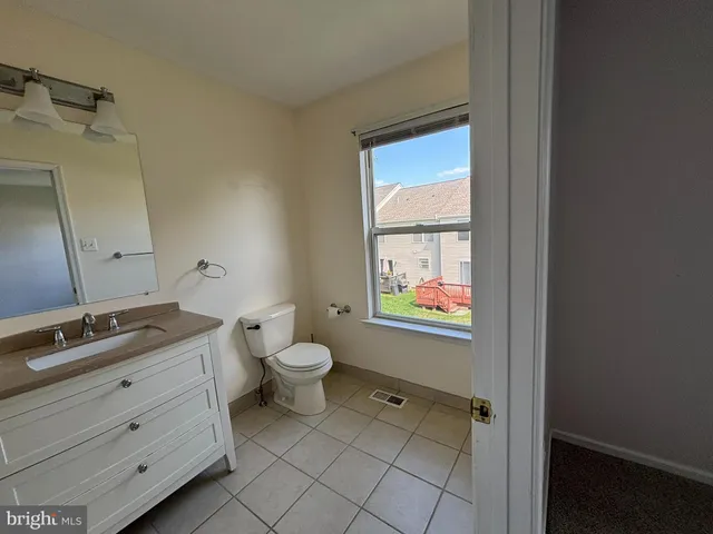 a bathroom with a granite countertop toilet sink and mirror
