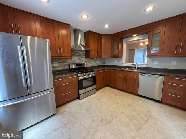 a kitchen with stainless steel appliances granite countertop a stove refrigerator sink and microwave