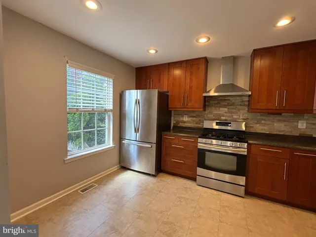 a kitchen with stainless steel appliances granite countertop a refrigerator stove and sink