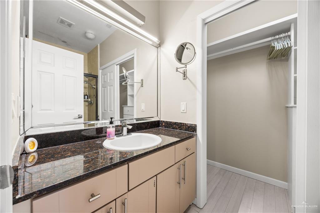 813 Travis Street, Unit 315 Mission, TX 78572 - Photo 12 of 25 a bathroom with a granite countertop sink and a mirror