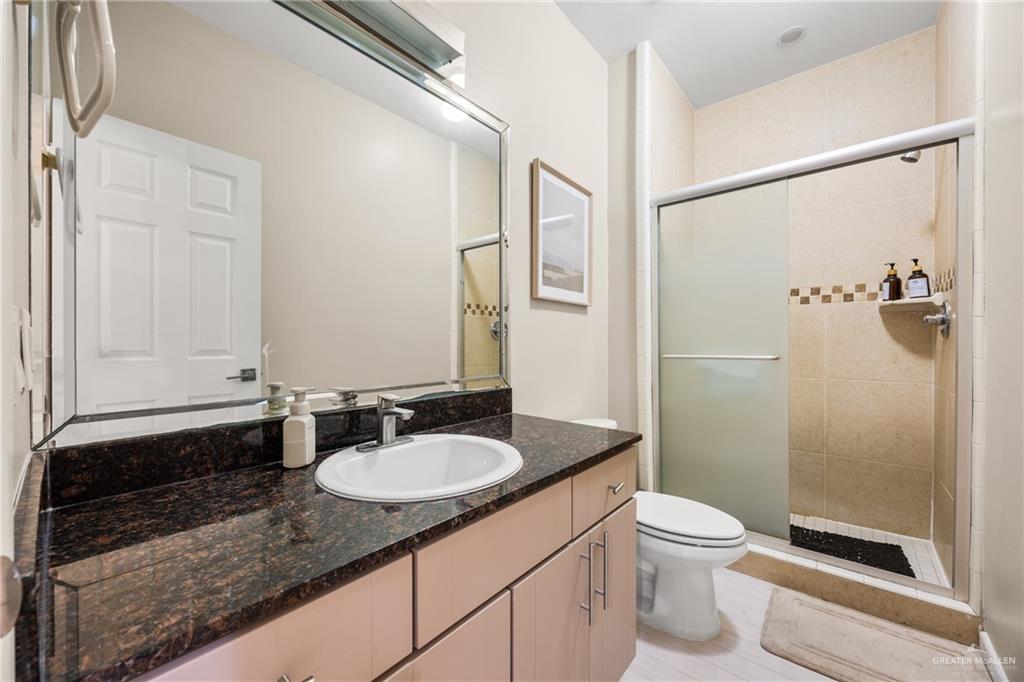 813 Travis Street, Unit 315 Mission, TX 78572 - Photo 14 of 25 a bathroom with a granite countertop sink toilet and shower